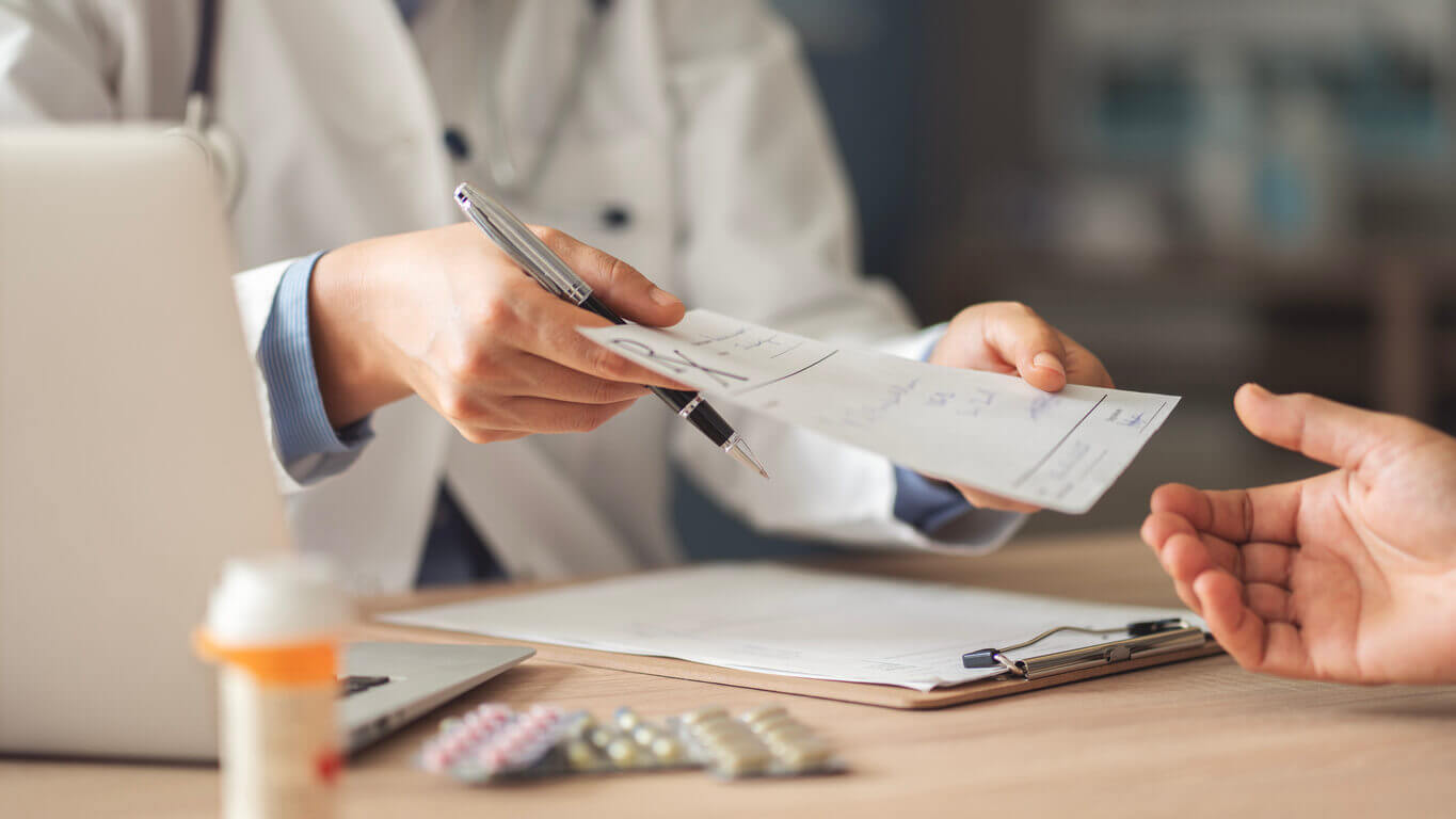 Medico em consultorio, receitando o uso de antibioticos para o paciente.